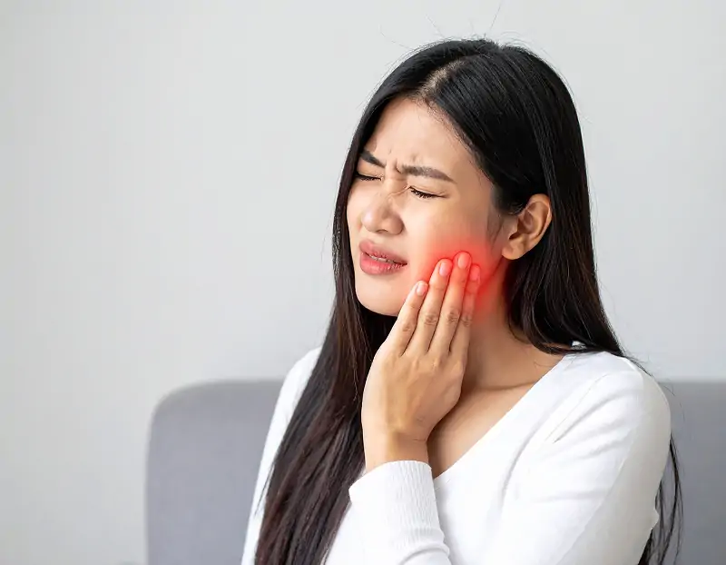 頬に手を添え痛がっている女性